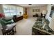 Comfortable living room featuring a floral sofa, artwork, and a cozy armchair at 11224 Yewtree Ave, Port Richey, FL 34668