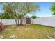 Backyard featuring a storage shed, a white fence, and large trees at 1219 Aladdin Rd, Spring Hill, FL 34609
