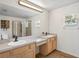 Bright bathroom featuring a double vanity, a large mirror, a shower with glass door and natural light at 1219 Aladdin Rd, Spring Hill, FL 34609
