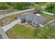 Aerial view of a gray home, featuring a long driveway, well-kept yard, and stylish architectural design at 1219 Aladdin Rd, Spring Hill, FL 34609