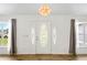 Bright foyer features a decorative front door with sidelights, tile flooring, and modern light fixture at 1219 Aladdin Rd, Spring Hill, FL 34609