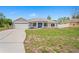Charming single-story home featuring a well-manicured lawn, attached garage, and a welcoming blue front door at 1219 Aladdin Rd, Spring Hill, FL 34609