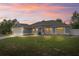 Charming single-story home with an attached garage, manicured lawn, and a welcoming blue front door during sunset at 1219 Aladdin Rd, Spring Hill, FL 34609