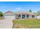 Charming single-story home featuring a well-manicured lawn, attached garage, and a welcoming blue front door at 1219 Aladdin Rd, Spring Hill, FL 34609