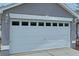Close up of a white garage door with windows and exterior lighting at 1219 Aladdin Rd, Spring Hill, FL 34609