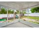 Enclosed lanai leading to a spacious backyard with a playset and white vinyl fence at 1219 Aladdin Rd, Spring Hill, FL 34609