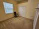 Bright, carpeted spare bedroom with closet and a chair at 12270 Clarendon Ct, Spring Hill, FL 34609