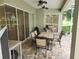 Charming covered patio boasts a table and chairs set, grill, and sliding glass doors for seamless indoor-outdoor living at 12270 Clarendon Ct, Spring Hill, FL 34609
