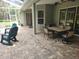 This covered patio has an outdoor table with chairs, ceiling fans, and a serene backyard view at 12270 Clarendon Ct, Spring Hill, FL 34609