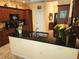 Spacious kitchen island featuring a black countertop, a modern faucet, and decorative wood cabinetry at 12270 Clarendon Ct, Spring Hill, FL 34609