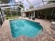 Large screened-in pool and patio area featuring a comfortable seating area, outdoor kitchen, and backyard views at 12270 Clarendon Ct, Spring Hill, FL 34609