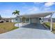 This home features a covered carport with a spacious driveway and a well-kept yard at 13411 Lisa Dr, Hudson, FL 34667