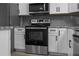 A kitchen featuring stainless steel appliances, a gray backsplash, white cabinets, and marbled countertops at 13411 Lisa Dr, Hudson, FL 34667