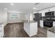 Open-concept kitchen features an island, stainless steel appliances, and flows seamlessly into the spacious living area at 13411 Lisa Dr, Hudson, FL 34667