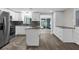 Kitchen with stainless steel appliances, modern cabinetry, stone countertops, and an island, adjacent to a sunroom at 13411 Lisa Dr, Hudson, FL 34667