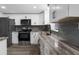 Modern kitchen with stainless steel appliances, gray backsplash, updated cabinets, and elegant marbled countertops at 13411 Lisa Dr, Hudson, FL 34667