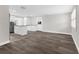 Spacious living room with updated kitchen, abundant natural light, and sleek wood-look flooring at 13411 Lisa Dr, Hudson, FL 34667
