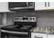Modern stainless steel oven and cooktop with white cabinets, gray subway tile backsplash, and marbled countertops at 13411 Lisa Dr, Hudson, FL 34667