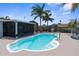 Backyard pool features mature palm trees and a serene pool side seating area at 13411 Lisa Dr, Hudson, FL 34667
