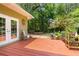 Cozy wood deck area with seating, plants, and access to the lush backyard at 14145 Citrus Way, Brooksville, FL 34601