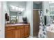 Bathroom showcases vanity with a sink, walk-in shower, and eucalyptus shower curtain at 14145 Citrus Way, Brooksville, FL 34601