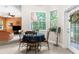 Bright breakfast nook features a round table, black chairs, and natural light from large windows overlooking lush greenery at 14145 Citrus Way, Brooksville, FL 34601