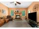 Warm living room features a fireplace, comfortable leather seating, large television and ample natural light at 14145 Citrus Way, Brooksville, FL 34601
