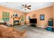Cozy living room features a fireplace, comfortable leather seating, ceiling fan, and a large flat-screen television at 14145 Citrus Way, Brooksville, FL 34601