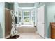 Serene main bathroom with a soaking tub, separate shower, and natural light from the bay windows at 14145 Citrus Way, Brooksville, FL 34601