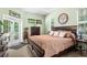 Bright main bedroom with a large bed, dresser, and French doors leading to a private outdoor space at 14145 Citrus Way, Brooksville, FL 34601