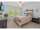 Serene bedroom with a cozy bed, soft lighting, and views of lush greenery through the windows at 16793 Forge Surf St, Land O Lakes, FL 34638