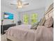 Comfortable bedroom featuring a cozy bed, a TV, and tranquil views of the outdoors at 16793 Forge Surf St, Land O Lakes, FL 34638