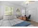 Well-lit bedroom featuring a comfortable bed, desk, and natural light from windows at 16793 Forge Surf St, Land O Lakes, FL 34638