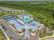 A stunning aerial view of a community center featuring a pool, tennis courts, and immaculate landscaping at 16793 Forge Surf St, Land O Lakes, FL 34638