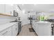 Modern, all-white kitchen with an island, stainless steel appliances, and an open floor plan at 16793 Forge Surf St, Land O Lakes, FL 34638