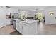 Open kitchen with a central island, stainless steel appliances, and a view into the dining and living areas at 16793 Forge Surf St, Land O Lakes, FL 34638