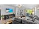 Bright living room featuring a modern fireplace, sleek furniture, and sliding glass doors to the outdoor patio at 16793 Forge Surf St, Land O Lakes, FL 34638