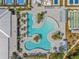 Overhead shot of the large community pool featuring winding sections, palms, lounge chairs, shuffleboard and tennis courts at 16793 Forge Surf St, Land O Lakes, FL 34638