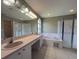 Bathroom with dual sinks, large mirror, separate shower, and soaking tub at 18109 Webster Grove Dr, Hudson, FL 34667