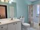 Bright bathroom featuring a white vanity, toilet, and shower-tub combination at 18109 Webster Grove Dr, Hudson, FL 34667