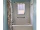 Bright bathroom features a shower-tub with patterned curtain and a window at 18109 Webster Grove Dr, Hudson, FL 34667
