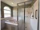 Main bathroom features a glass shower, tub, and a large window at 18109 Webster Grove Dr, Hudson, FL 34667