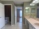 Bathroom with dual sinks and neutral countertops with tile flooring at 18109 Webster Grove Dr, Hudson, FL 34667