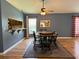 Spacious dining room features hardwood floors, a large table with seating for six, and a pass-through to the kitchen at 18109 Webster Grove Dr, Hudson, FL 34667