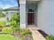 Inviting front entry with a stylish door, sidelight window, and decorative light fixture at 18109 Webster Grove Dr, Hudson, FL 34667