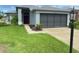 Charming single-story home with a manicured lawn, two-car garage, and inviting entryway at 18109 Webster Grove Dr, Hudson, FL 34667