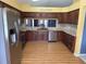 A kitchen features wooden cabinets, granite countertops, stainless steel appliances, and an open view to another room at 18109 Webster Grove Dr, Hudson, FL 34667