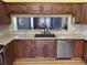 A kitchen features wooden cabinets, granite countertops, and a stainless steel dishwasher at 18109 Webster Grove Dr, Hudson, FL 34667