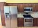 This is a spacious kitchen with wooden cabinets, granite countertops, and stainless steel appliances at 18109 Webster Grove Dr, Hudson, FL 34667
