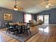 This open-concept living area showcases hardwood floors, a dining table, comfortable seating, and access to the outdoors at 18109 Webster Grove Dr, Hudson, FL 34667